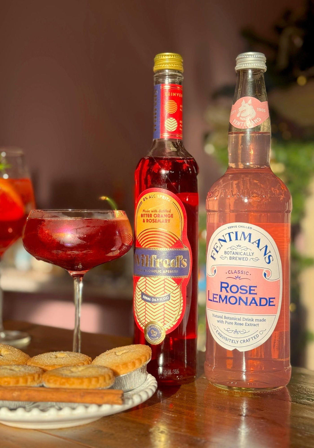 Wilfreds Rose & Cherry Spritz on a festive spread of mince pies beside a bottle of Fentimans Rose Lemonade