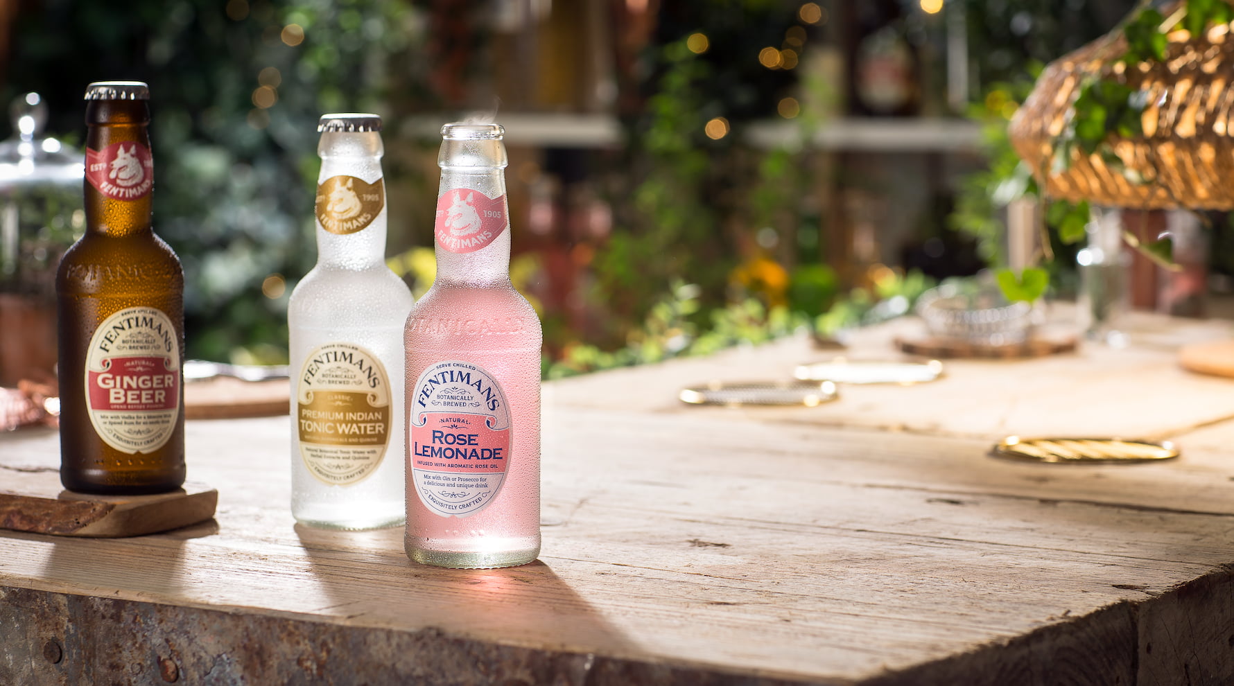 Fentimans Ginger Beer, Premium Indian Tonic Water and Rose Lemonade on a garden table